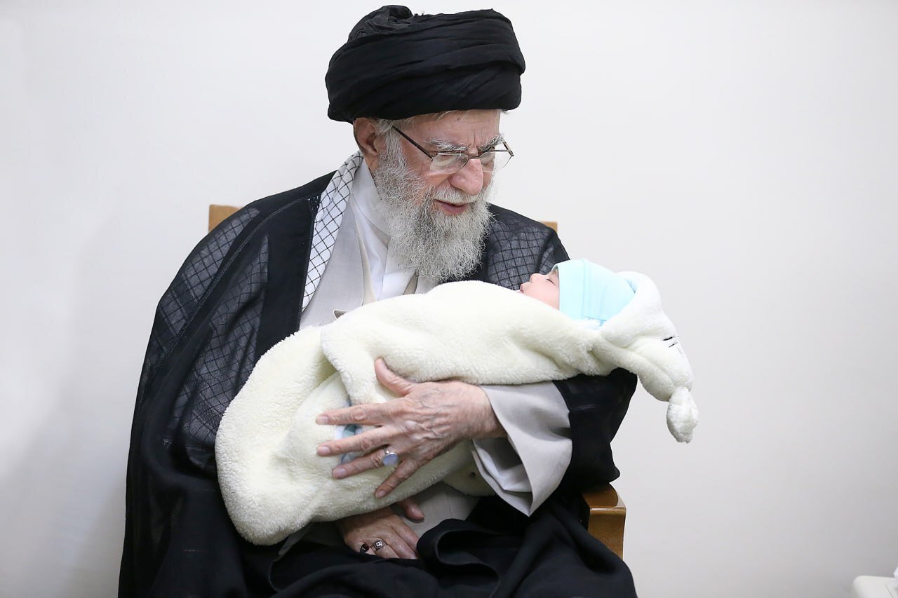 تصویری خاص از اذان گفتن رهبر انقلاب در گوش نوزاد شهید حمزه جهاندیده